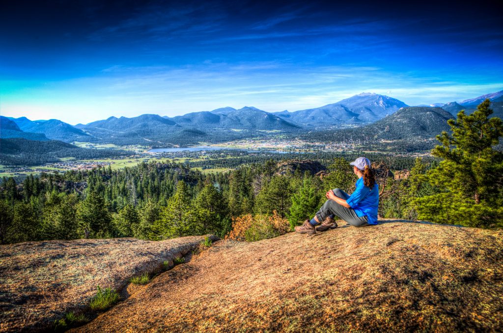 Woman overlooking Estes Park mountain landscape, representing nature exploration and creativity behind Spartanburg SC photography services.